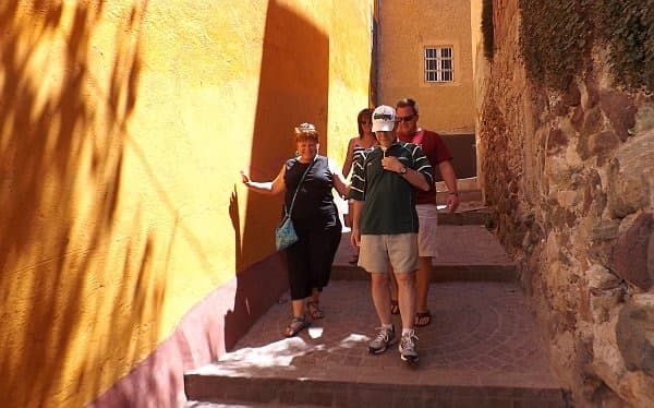 Guests walking up an ochre alley in Guanajuato